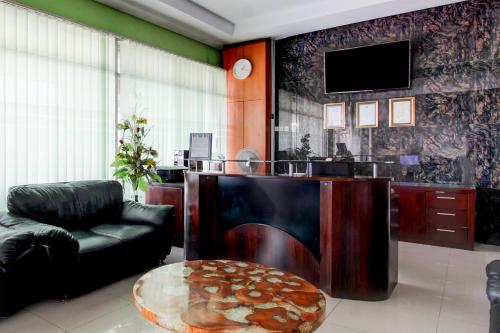 a living room with a couch and a table and a tv at OYO 94697 Hotel Amanah Sejahtera in Solo