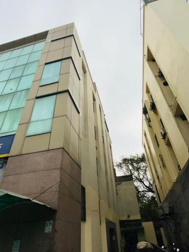 a tall building with glass windows on the side of it at Hotel Imperial Inn - Nehru Place in New Delhi