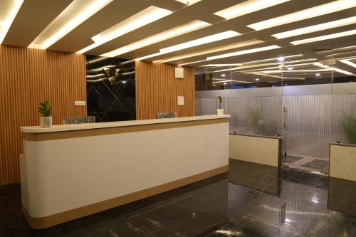 a lobby with a reception counter in a building at Hotel Vamshi Elite in Kondapur