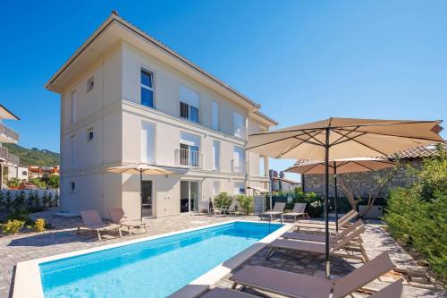 a villa with a swimming pool and a building at Apartment in Villa Marealto with pool, garage and seaview in Ičići