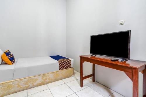a living room with a tv and a table at SPOT ON 94730 The Chatter Place Dipatiukur in Bandung