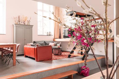 a living room with a red couch and a table at Mille Fleur Apartments in Voeren