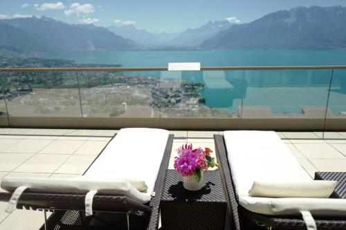 a balcony with two lounge chairs with a view of the water at Le Mirador Resort & Spa in Vevey