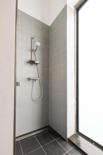 a shower with a glass door in a bathroom at Mille Fleur Apartments in Voeren