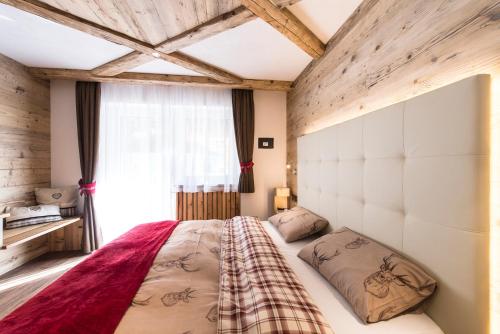 a bedroom with a large bed in a room at Alpstyle Hotel Albolina Wellness & Beauty in Canazei