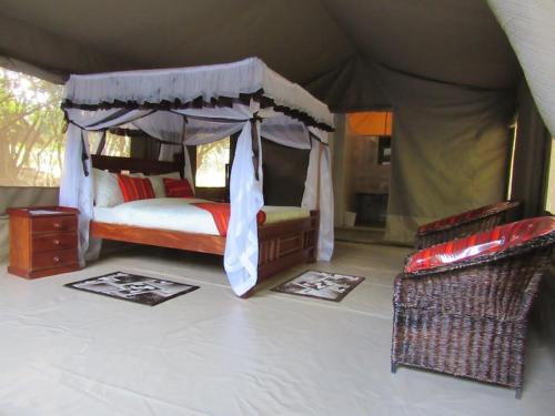 a bedroom with a canopy bed in a tent at Mara Sidain safaris in Sekenani