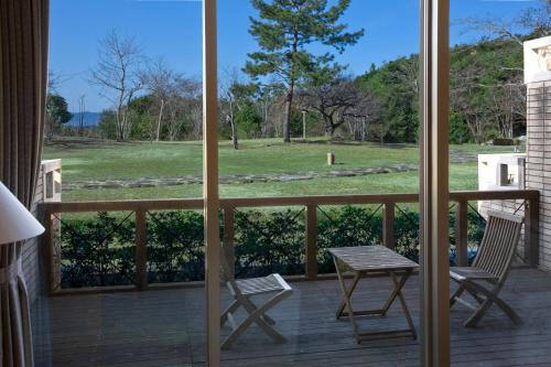 a view from a porch with two chairs and a table at Miyako Resort Okushima Aqua Forest in Shima