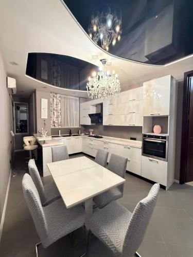 a kitchen with a table and chairs and a chandelier at Квартира в центре Тбилиси in Tbilisi City