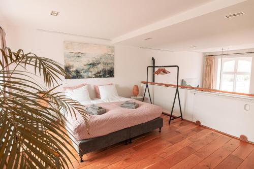 a bedroom with a bed and a plant at Mille Fleur Apartments in Voeren