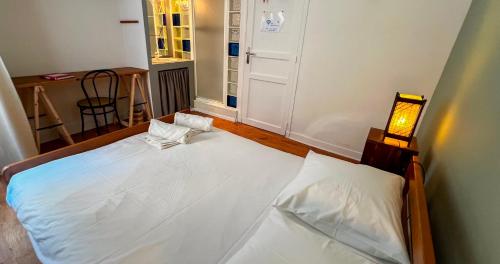 Un dormitorio con una gran cama blanca en una habitación. en Une Terrasse sur Avignon, en Aviñón