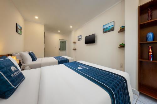 a bedroom with a bed and a tv on the wall at Mountain Pearl Hotel in Cat Ba