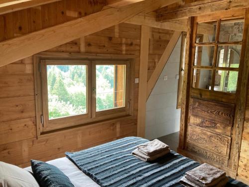 a bedroom with a bed in a wooden house at Chalet La Telier in Montriond
