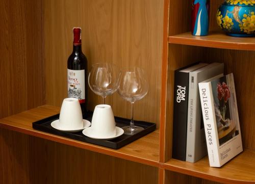 a bottle of wine and two glasses on a shelf at Mountain Pearl Hotel in Cat Ba