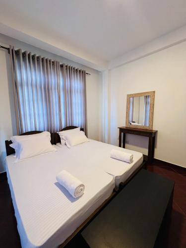 a bedroom with a large bed with towels on it at TranquilZ in Kandy