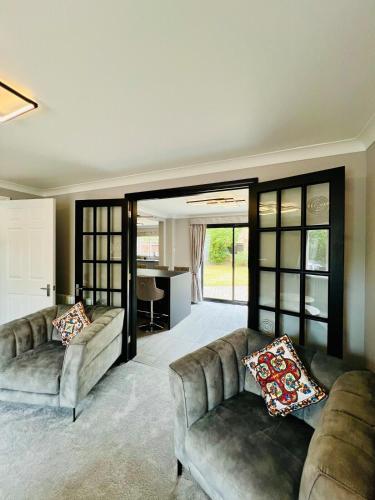 a living room with two couches and a kitchen at Poppies in Colchester