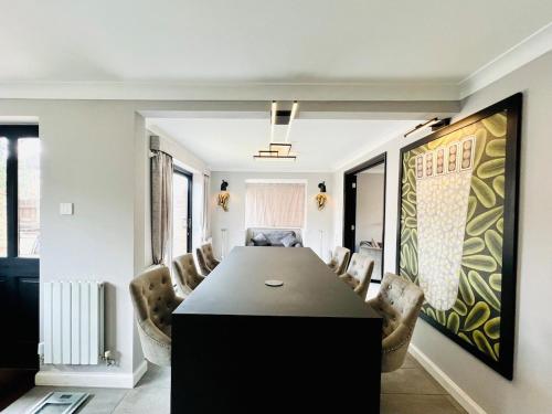 a dining room with a black table and chairs at Poppies in Colchester