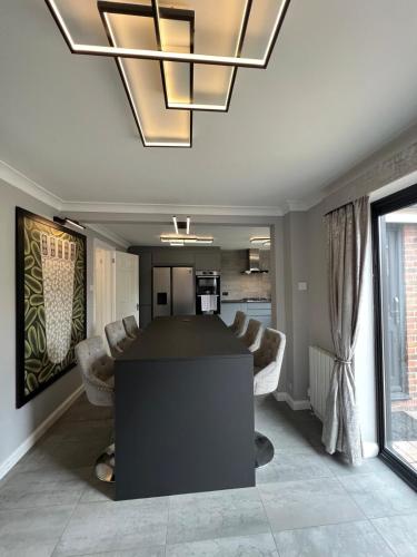 a kitchen and living room with a table and a chandelier at Poppies in Colchester