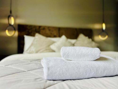 two towels are stacked on top of a bed at Poppies in Colchester