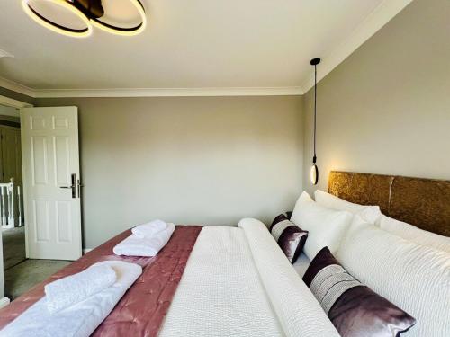 a bedroom with a large bed with two pillows at Poppies in Colchester