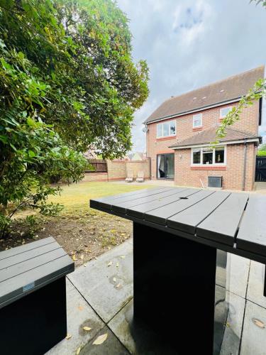 a picnic table with two benches in a yard at Poppies in Colchester
