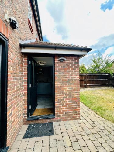 a brick building with a door open on a patio at Poppies in Colchester