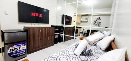a living room with a tv and a bed in a room at LG318 New Brenthill Premium Condo near SMBaguio in Baguio