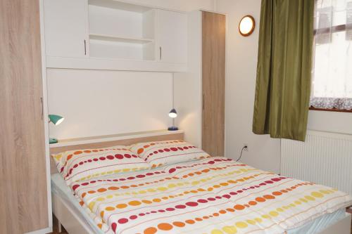 ein Bett mit einer bunten Decke auf einem Zimmer in der Unterkunft Apartment Pokos in Varaždinske Toplice