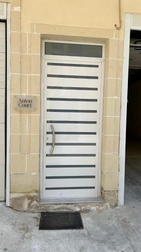 a white garage door on a brick building at Anton Court in Xlendi