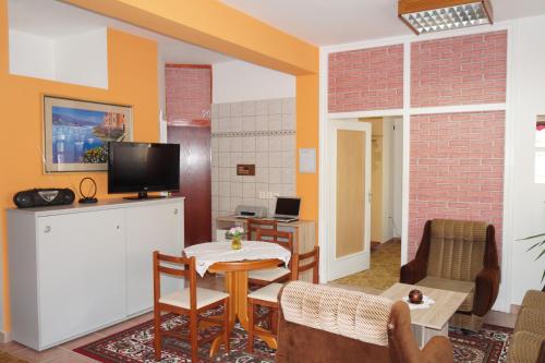 ein Wohnzimmer mit einem Tisch und einem TV in der Unterkunft Apartment Pokos in Varaždinske Toplice