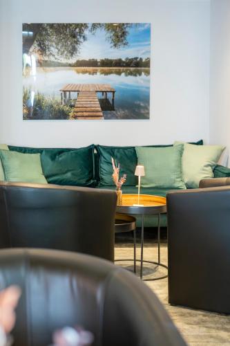 a room with a couch and a table with a picture on the wall at Sopherl am See - Frühstück auf der Seeterrasse, sehr ruhig und wunderschön am See, 3 Minuten nach Oberpfaffenhofen, viele Radtouren, Restaurants & Cafes in der Umgebung in Weßling