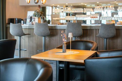 a restaurant with a wooden table and leather chairs at Sopherl am See - Frühstück auf der Seeterrasse, sehr ruhig und wunderschön am See, 3 Minuten nach Oberpfaffenhofen, viele Radtouren, Restaurants & Cafes in der Umgebung in Weßling