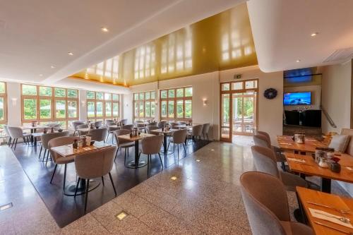 a restaurant with tables and chairs in a room at Sopherl am See - Frühstück auf der Seeterrasse, sehr ruhig und wunderschön am See, 3 Minuten nach Oberpfaffenhofen, viele Radtouren, Restaurants & Cafes in der Umgebung in Weßling