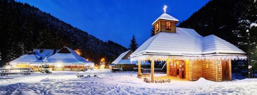 a building covered in snow with a clock tower at U dobrého pastiera in Ružomberok