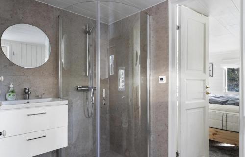 Un baño con ducha, lavabo y espejo. en Mysig skogsstuga mitt i naturen, en Våxtorp