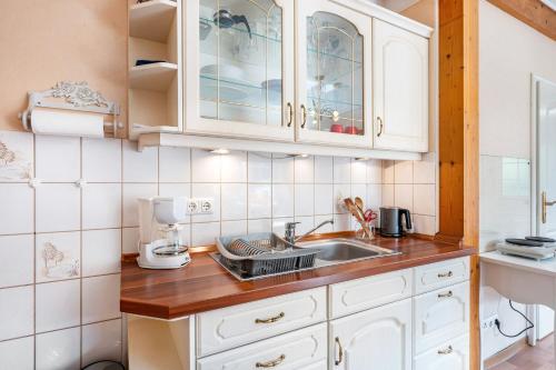 a kitchen with white cabinets and a sink at Gästehaus Ziegler in Neuenkirchen