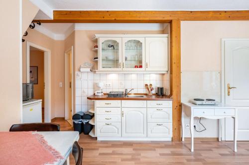 a kitchen with white cabinets and a sink at Gästehaus Ziegler in Neuenkirchen