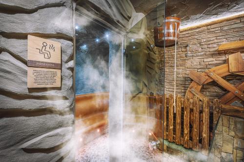 a steam shower in a room with a stone wall at U dobrého pastiera in Ružomberok