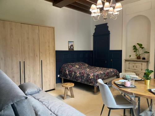 a bedroom with a bed and a table and a couch at Appartement confortable aux Andelys - 90 m² avec parking in Les Andelys