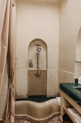 a bath tub in a bathroom with a shower at Riad Kasbah privilège and SPA in Marrakech