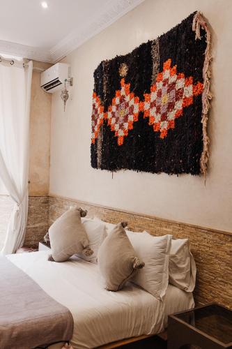a bedroom with a bed and a painting on the wall at Riad Kasbah privilège and SPA in Marrakech
