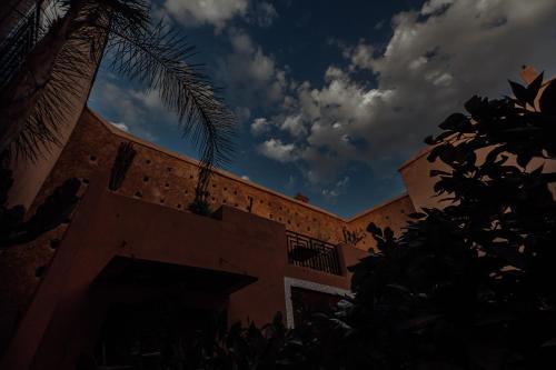 a building with a palm tree on the side of it at Riad Kasbah privilège and SPA in Marrakech