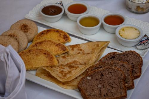 a white plate with bread and some dipping sauces at Riad Kasbah privilège and SPA in Marrakech