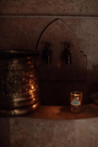 a counter top with two faucets and a candle at Riad Kasbah privilège and SPA in Marrakech