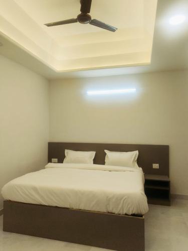 a bedroom with a bed with a ceiling fan at Hotel Connecting Home Stays in Hingni
