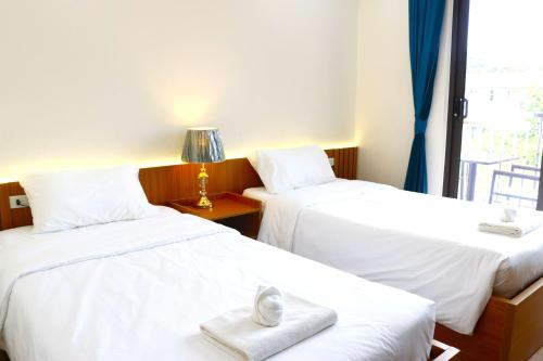 a hotel room with two beds with towels on them at Hoang Kim Hotel in Vientiane