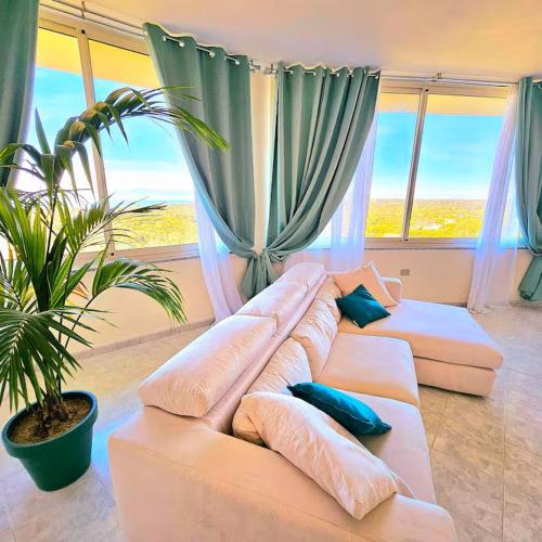 a living room with a large white couch with pillows at Villa Mary Holiday Home Near Villasimius in Quartu SantʼElena