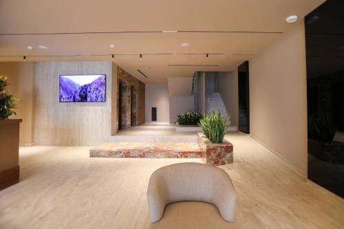 a living room with a couch and a tv on the wall at Sol Boutique Hotel in Vlorë
