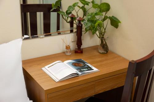 a table with an open book on a table with a window at Mountain Pearl Hotel in Cat Ba