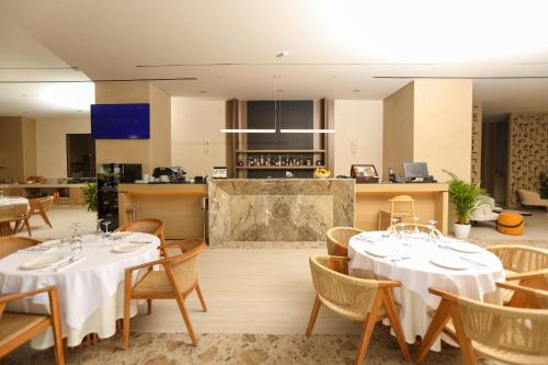 a restaurant with tables and chairs and a kitchen at Sol Boutique Hotel in Vlorë