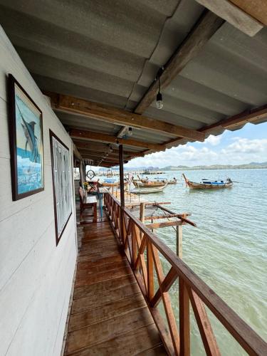 una passerella di legno su una barca in acqua di Kaneng Homestaykohpu a Ban Klang